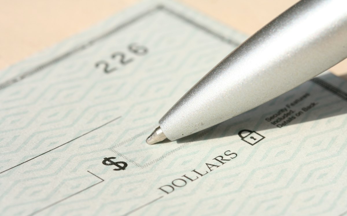Caneta preenchendo um cheque