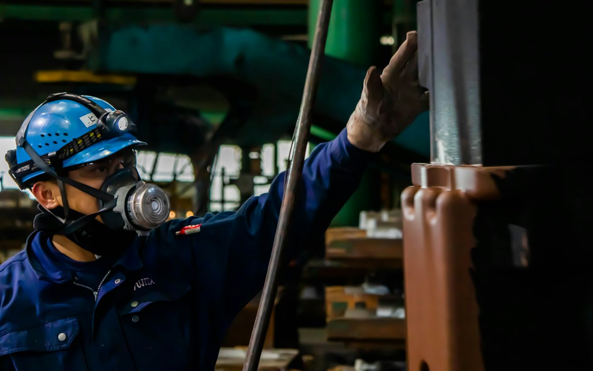 Trabalhador de capacete e máscara de proteção em uma indústria