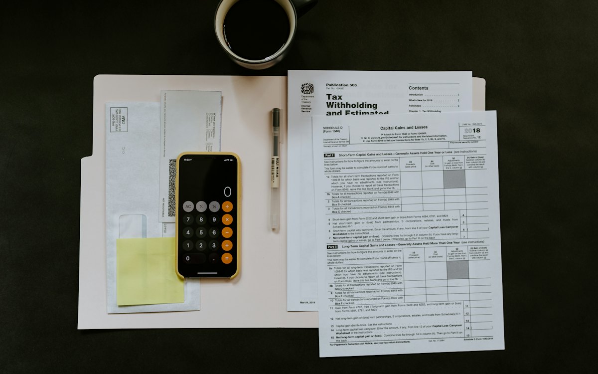 Documentos, extratos e calculadora sobre uma mesa escura