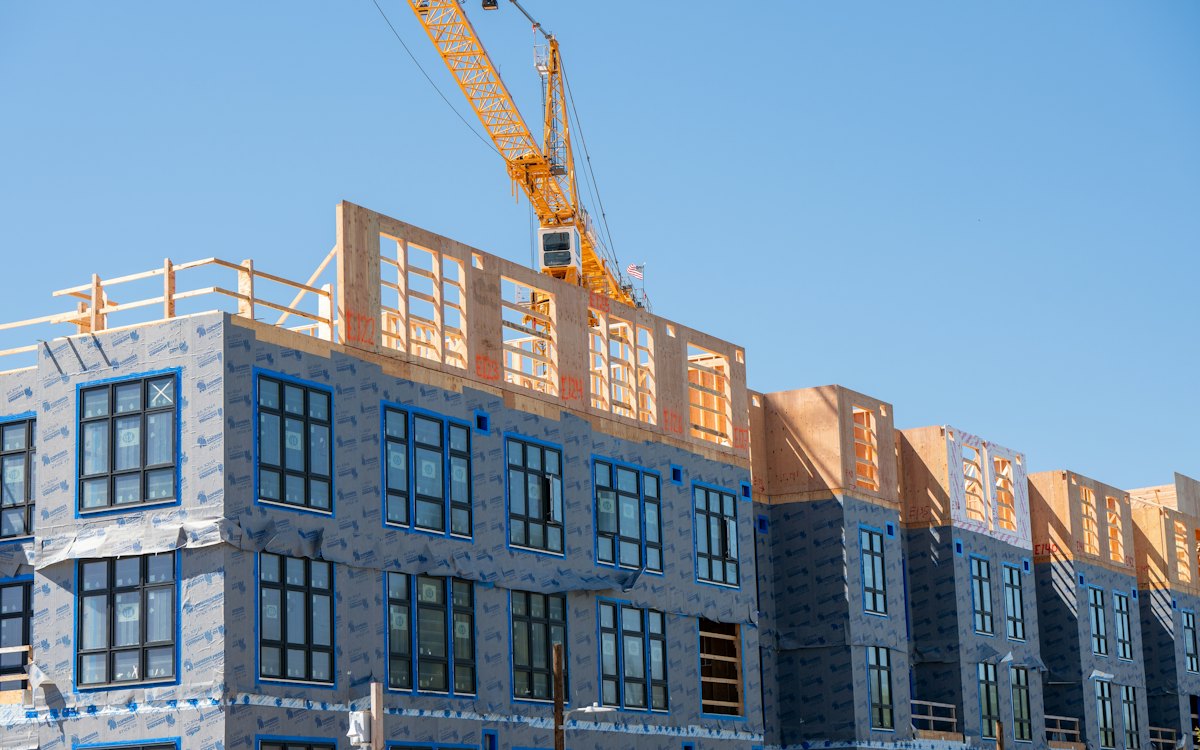 Prédio residencial em construção com guindaste ao fundo