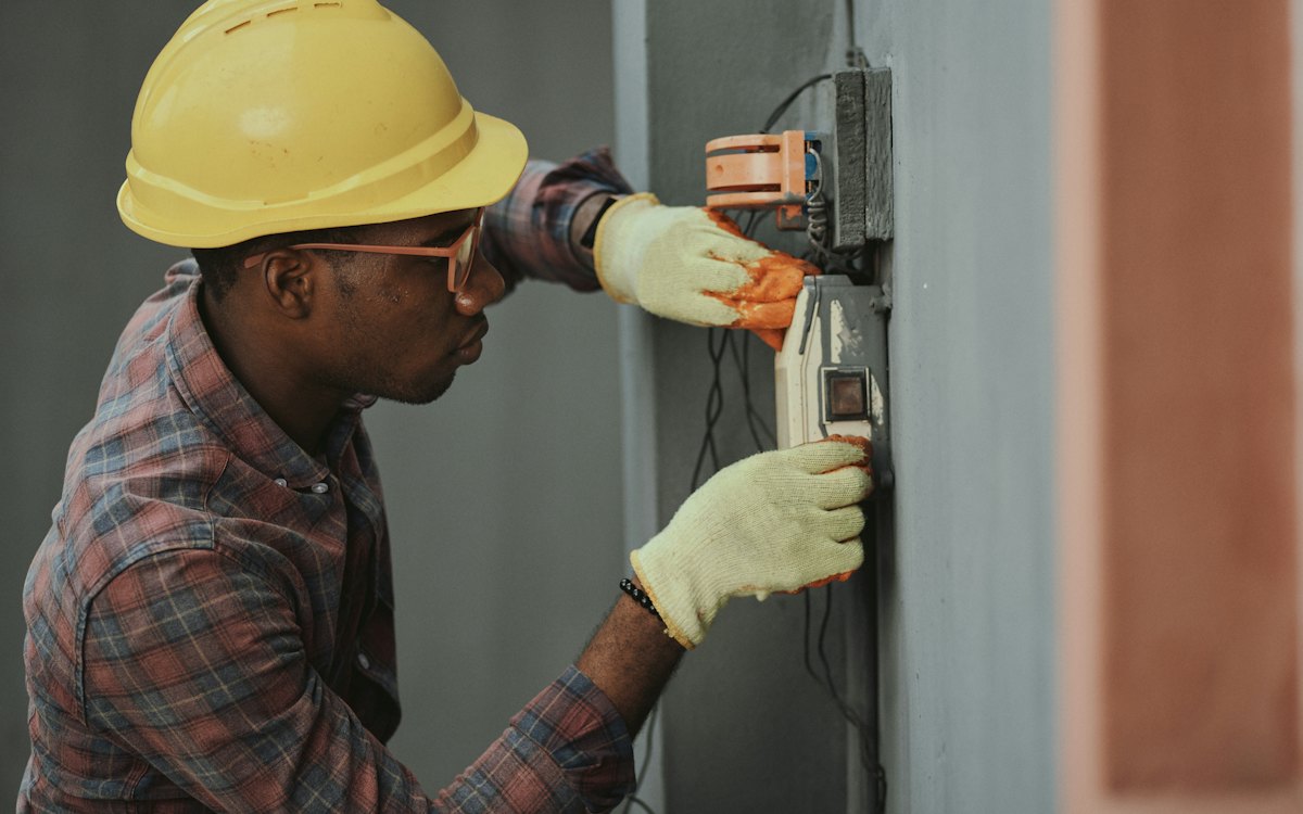 Eletricista de capacete trabalhando em um medidor de energia