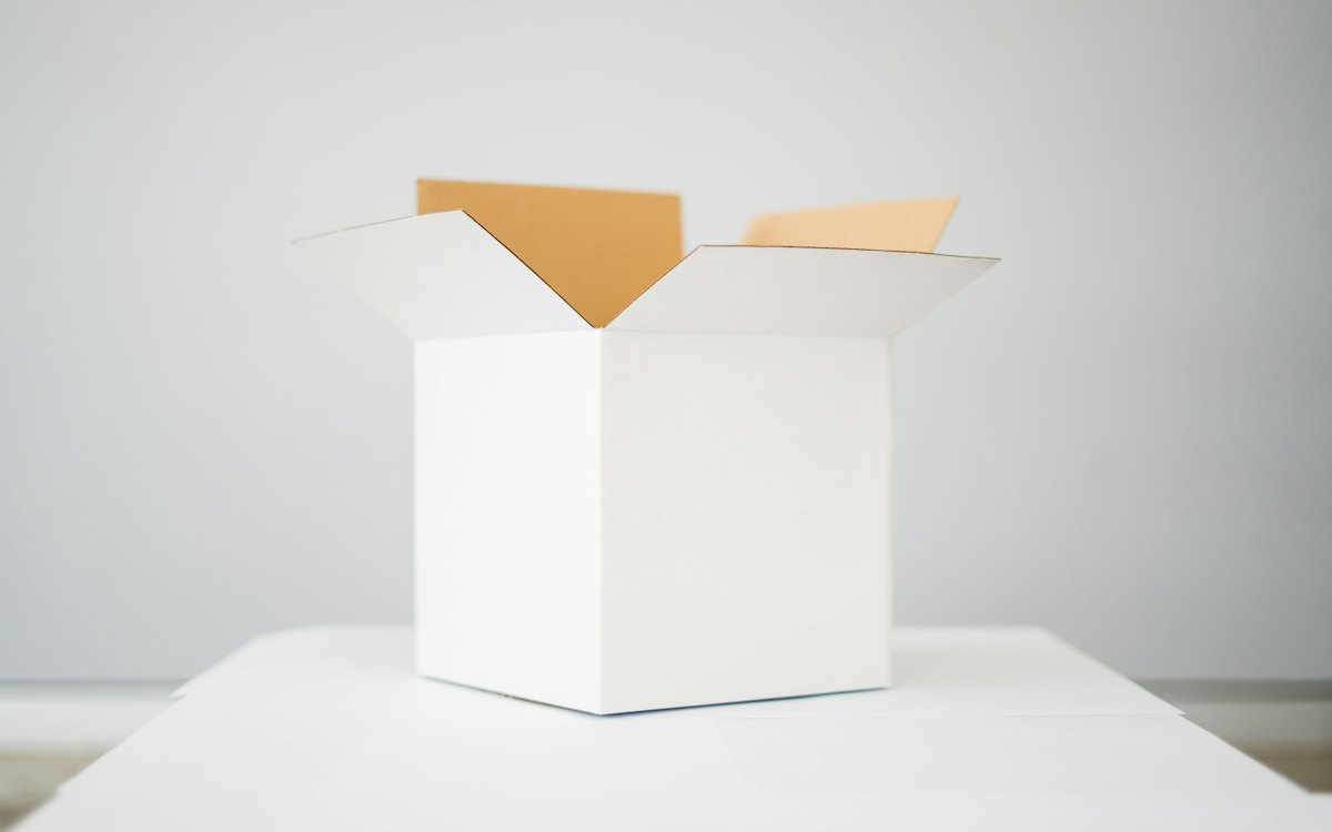 Caixa de papelão aberta sobre uma mesa branca