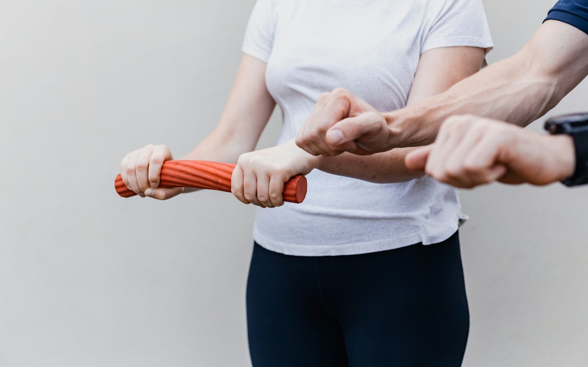 Fisioterapeuta orientando exercício de punho com faixa elástica