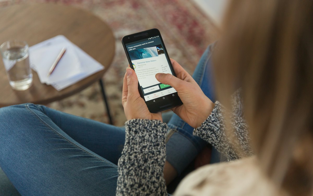 Mãos segurando um celular com aplicativo aberto