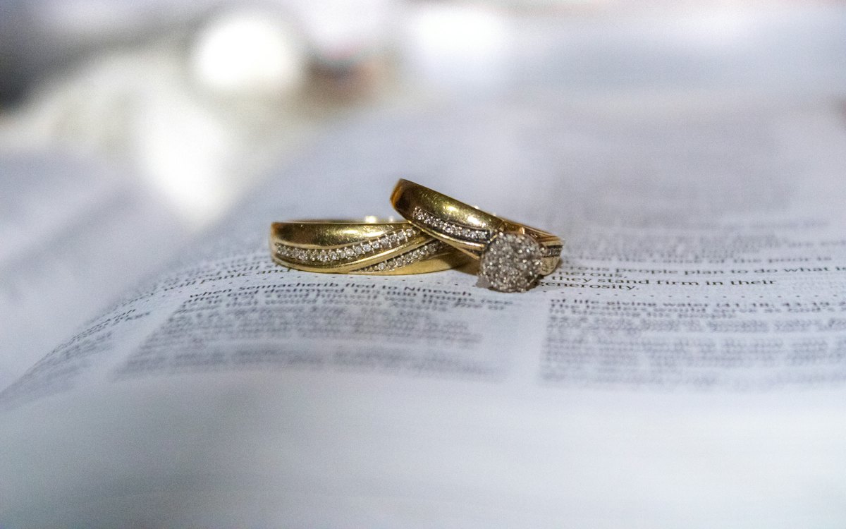 Alianças de casamento apoiadas sobre um documento impresso