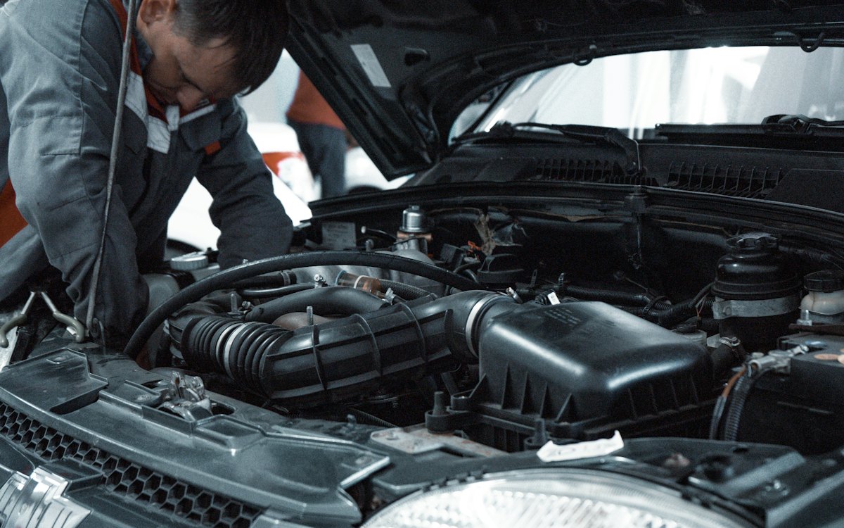 Mecânico examinando o motor de um carro com o capô aberto